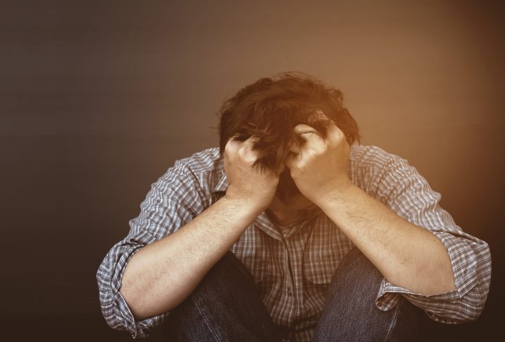 Sad man holding head with hand